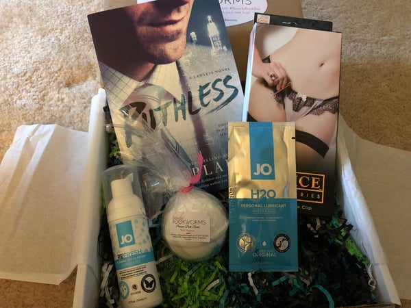 Most of the contents of the box, including a book, a toy, a bath bomb, cleaner, and a sample
