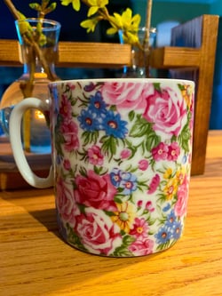 Photo of a white mug with a floral design placed on a table